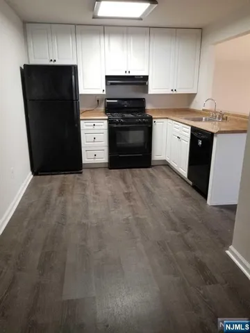 a kitchen with stainless steel appliances granite countertop a refrigerator and a stove