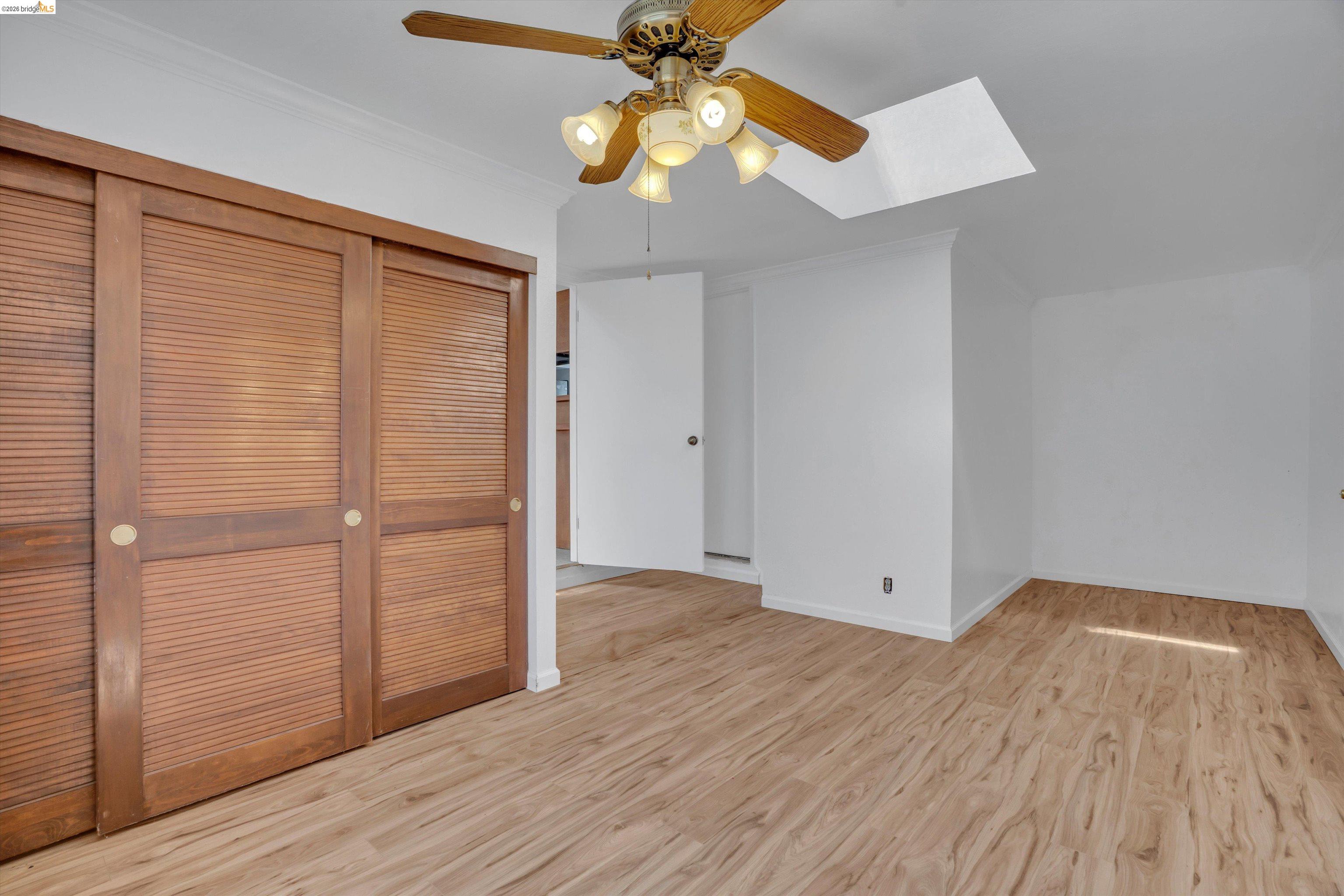 1922 Taylor Road Bethel Island, CA 94511 - Photo 21 of 49 Unfurnished bedroom featuring light wood-style flooring, a skylight, crown molding, a closet, and a ceiling fan