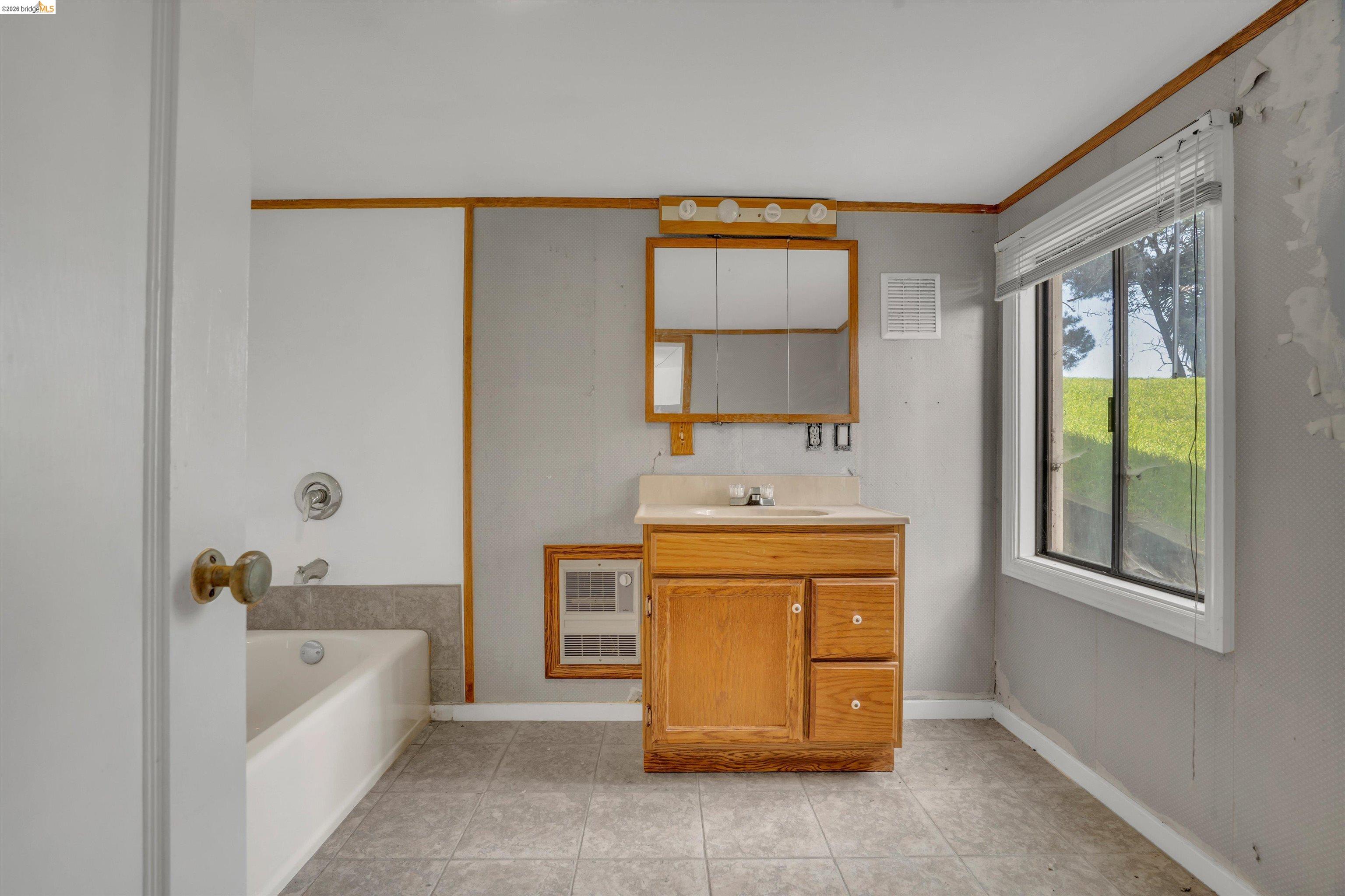 1922 Taylor Road Bethel Island, CA 94511 - Photo 30 of 49 Bathroom featuring vanity, a bath, ornamental molding, heating unit, and light tile patterned floors