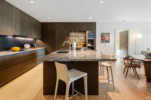 a kitchen with granite countertop a table chairs stove and cabinets