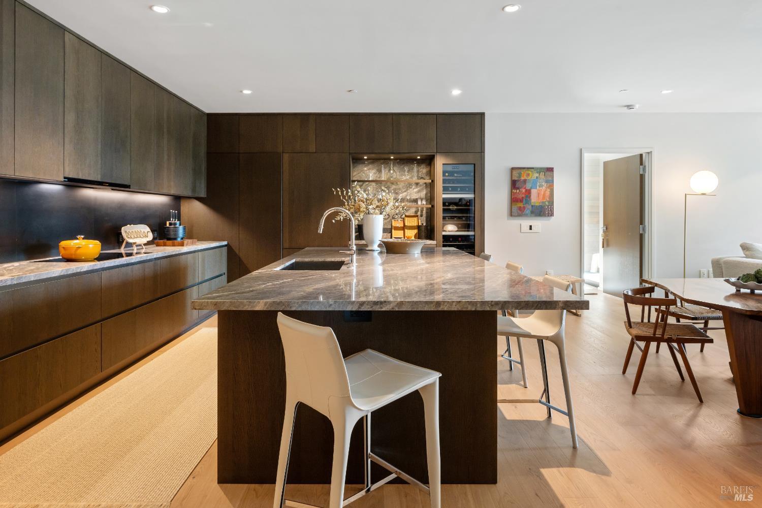 171 Sawmill Circle, Unit 304 Healdsburg, CA 95448 - Photo 10 of 28 a kitchen with granite countertop a table chairs stove and cabinets