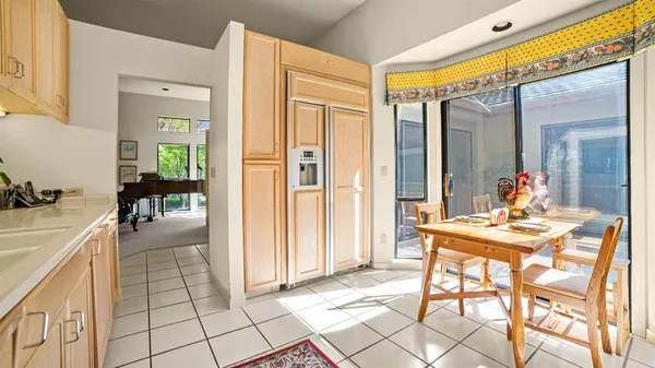 a view of a hallway with dining area and glass windows