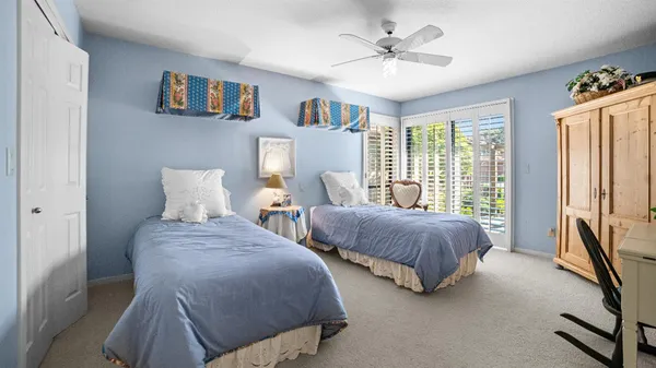 a spacious bedroom with two beds and a chandelier