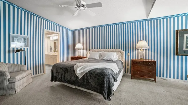 a spacious bedroom with a bed and a chandelier