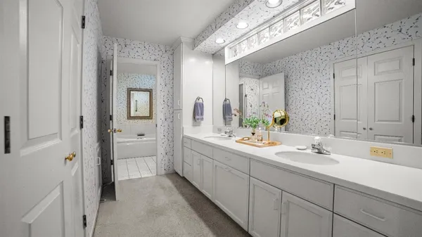 a spacious bathroom with a double vanity sink a mirror and a
