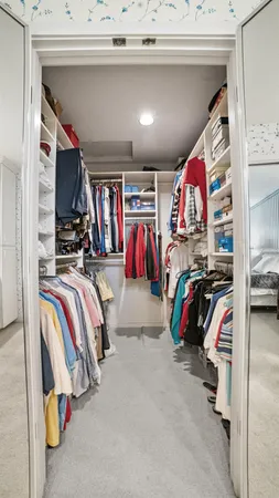 a view of walk in closet with clothes and shoes