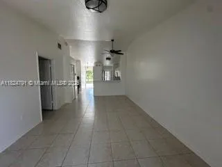 a kitchen with stainless steel appliances a refrigerator a stove a sink a dining table and chairs with wooden floor