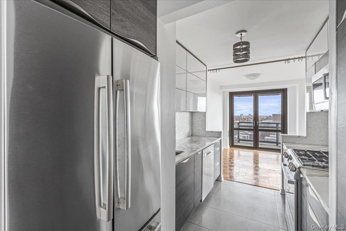 112-01 Queens Boulevard, Unit 23C Queens, NY 11375 - Photo 11 of 32 a kitchen with stainless steel appliances granite countertop a refrigerator and a stove