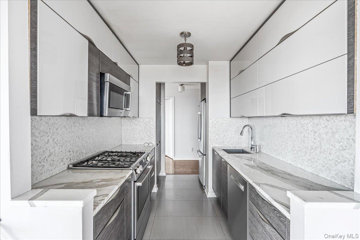 112-01 Queens Boulevard, Unit 23C Queens, NY 11375 - Photo 12 of 32 a kitchen with stainless steel appliances granite countertop a sink stove and refrigerator
