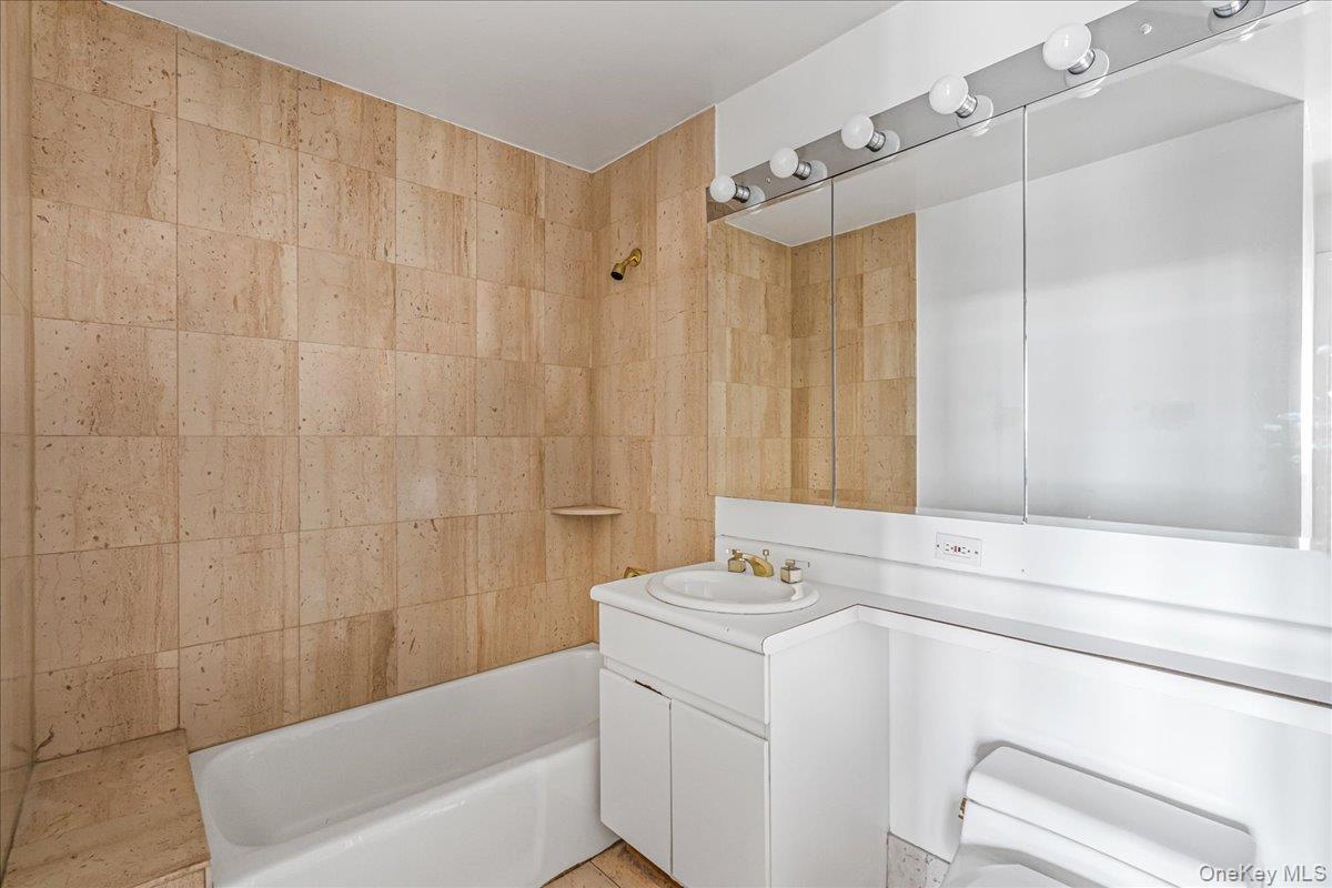 112-01 Queens Boulevard, Unit 23C Queens, NY 11375 - Photo 18 of 32 a bathroom with a sink a toilet and shower