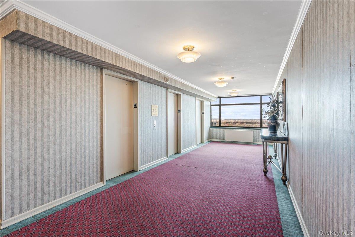 112-01 Queens Boulevard, Unit 23C Queens, NY 11375 - Photo 27 of 32 a view of a hallway to a livingroom with furniture and window