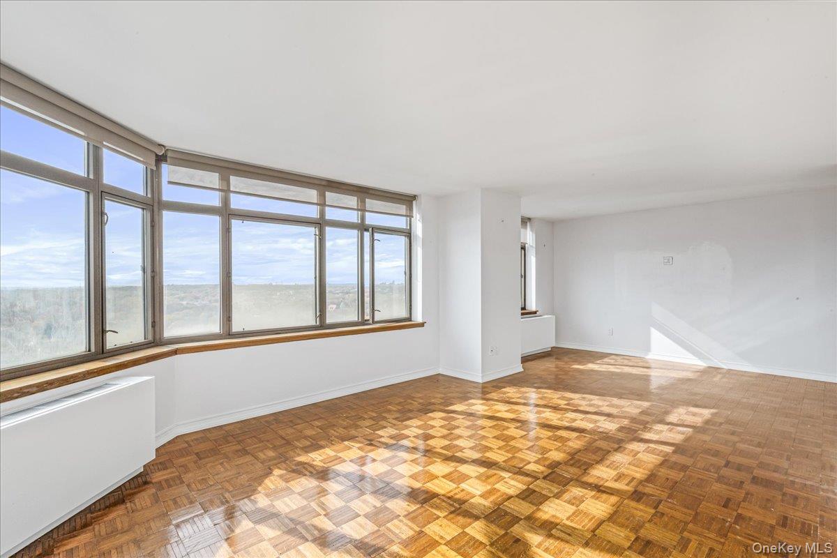 112-01 Queens Boulevard, Unit 23C Queens, NY 11375 - Photo 7 of 32 a view of empty room with wooden floor and fan