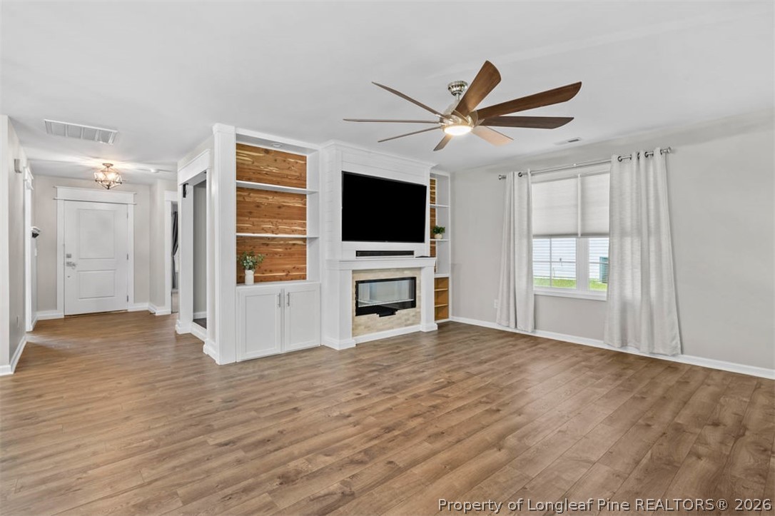 83 Kotata Avenue Bunnlevel, NC 28323 - Photo 20 of 49 a view of a livingroom with a flat screen tv ceiling fan and hardwood floor