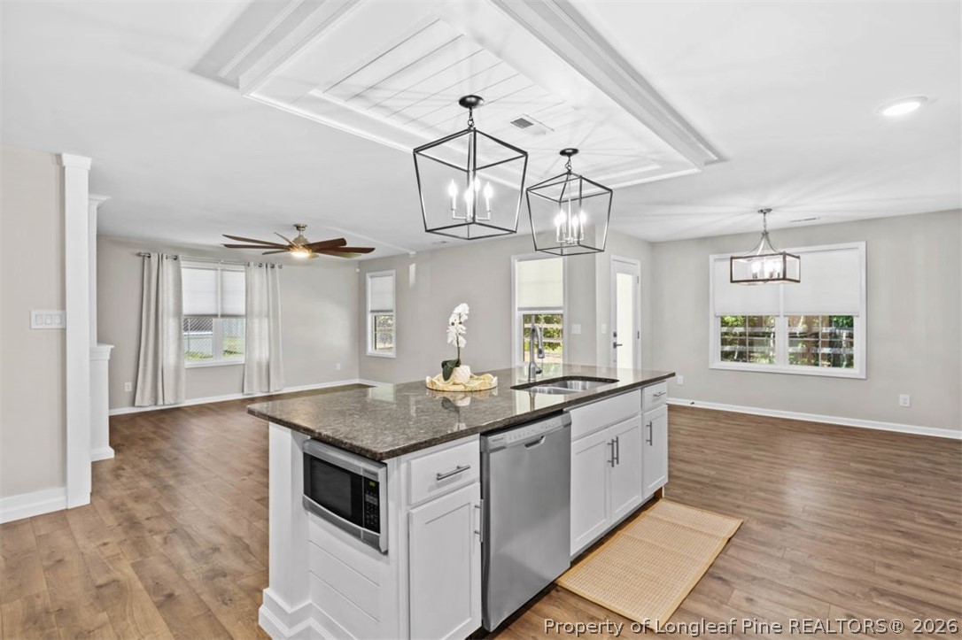 83 Kotata Avenue Bunnlevel, NC 28323 - Photo 28 of 49 a kitchen with stainless steel appliances granite countertop a sink dishwasher and white cabinets with wooden floor