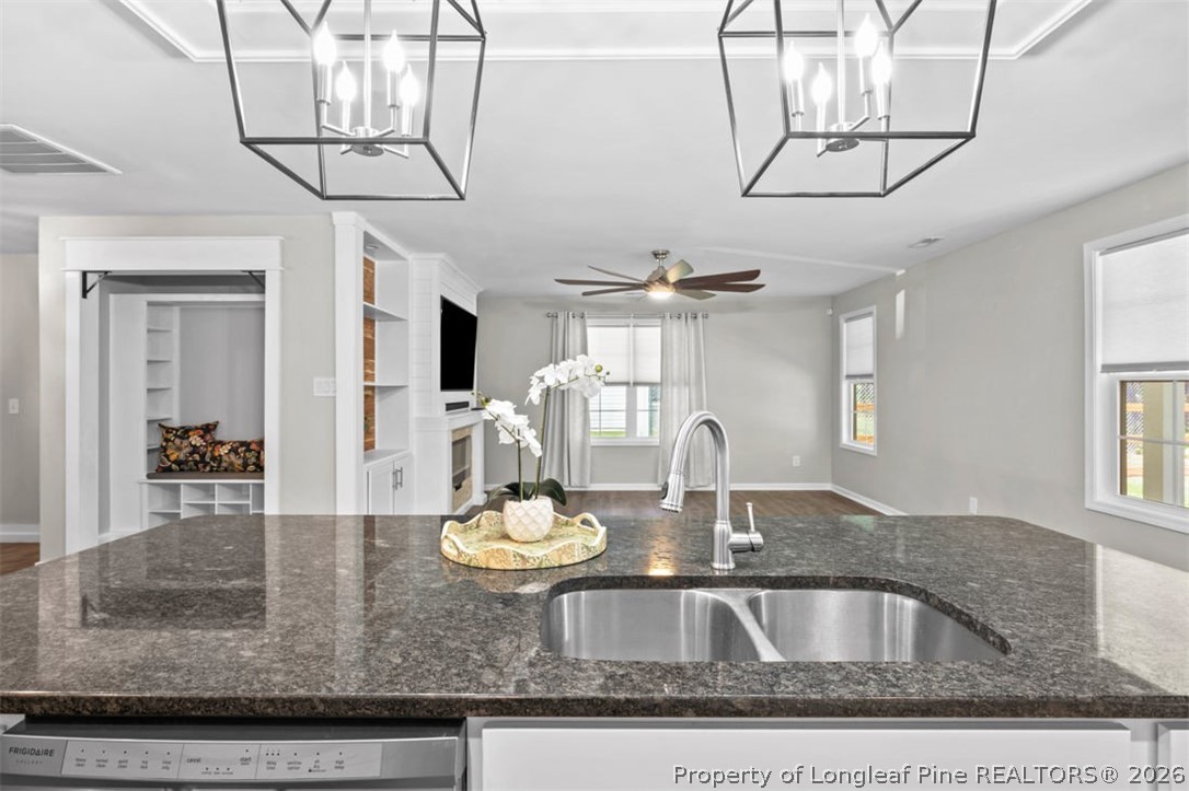 83 Kotata Avenue Bunnlevel, NC 28323 - Photo 29 of 49 a kitchen with a granite countertop sink and wooden floor
