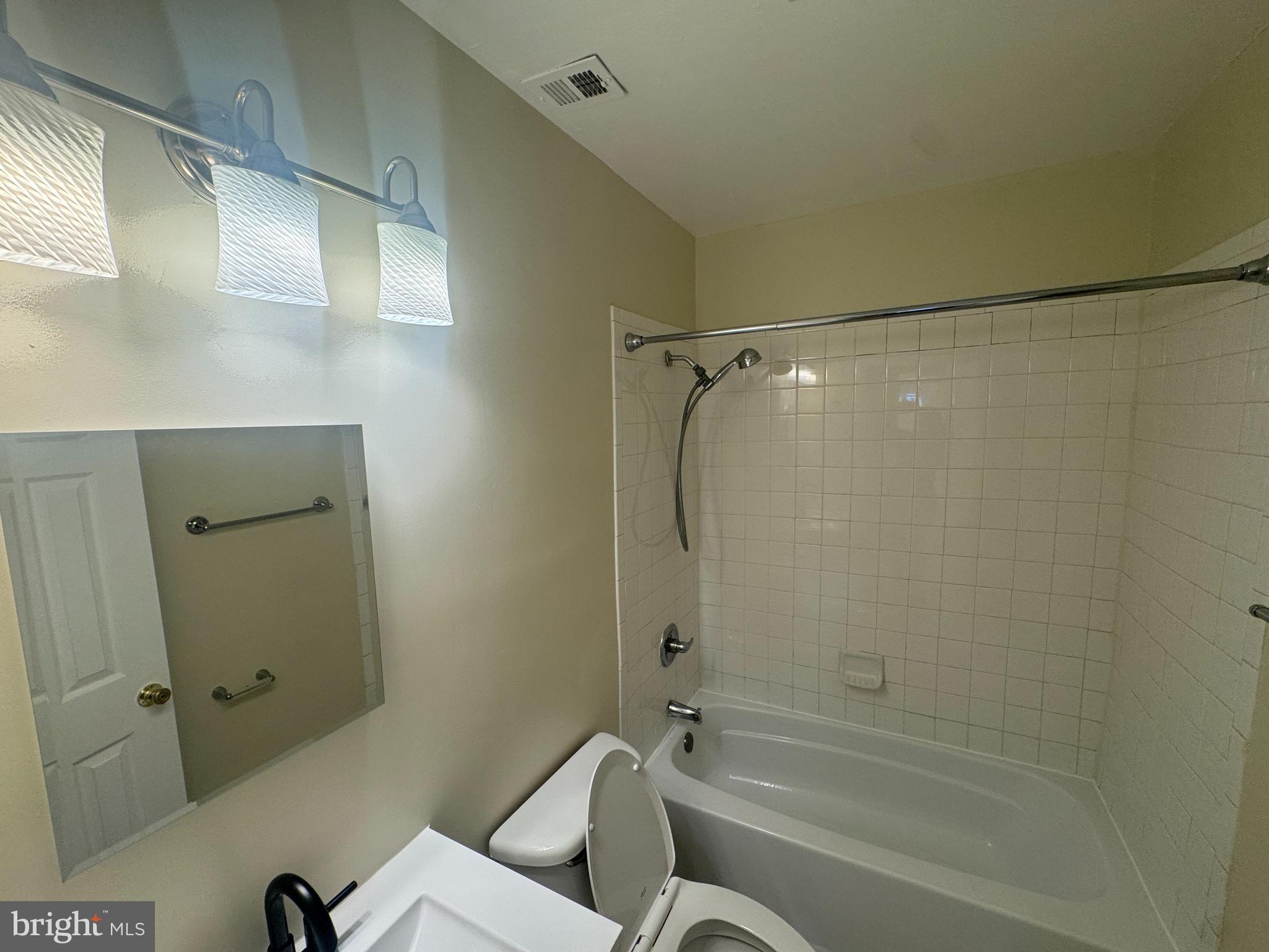 2810 Xavier Lane District Heights, MD 20747 - Photo 13 of 27 a bathroom with a granite countertop bathtub shower sink vanity and toilet