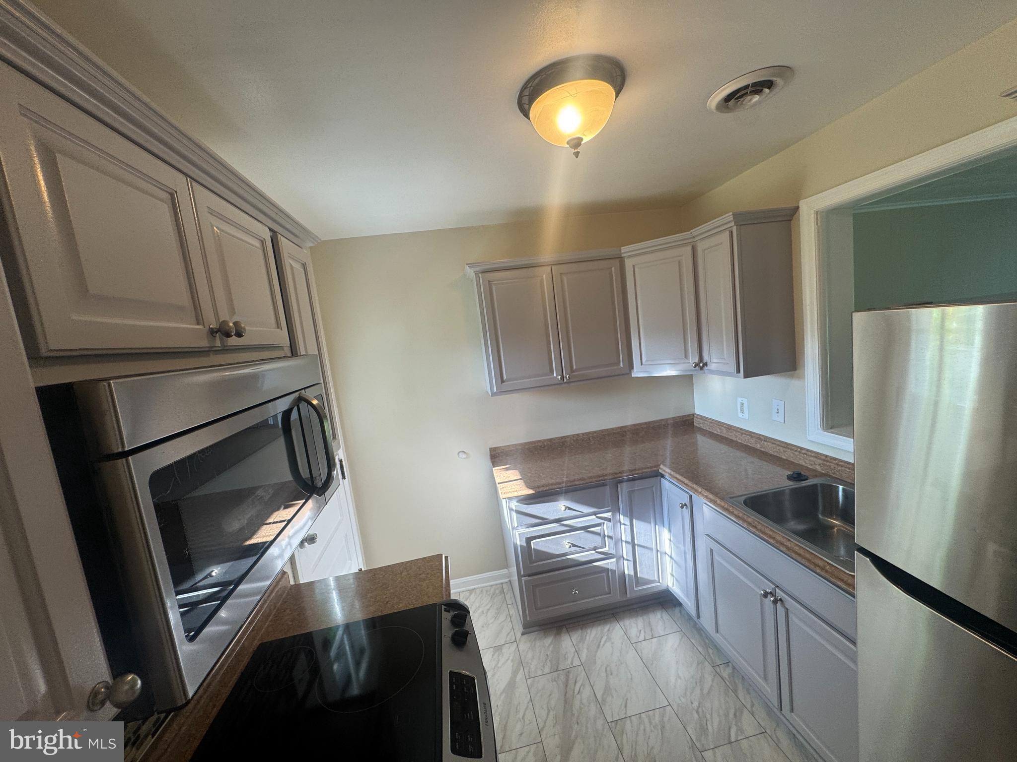 2810 Xavier Lane District Heights, MD 20747 - Photo 2 of 27 a kitchen with granite countertop a refrigerator stove and microwave