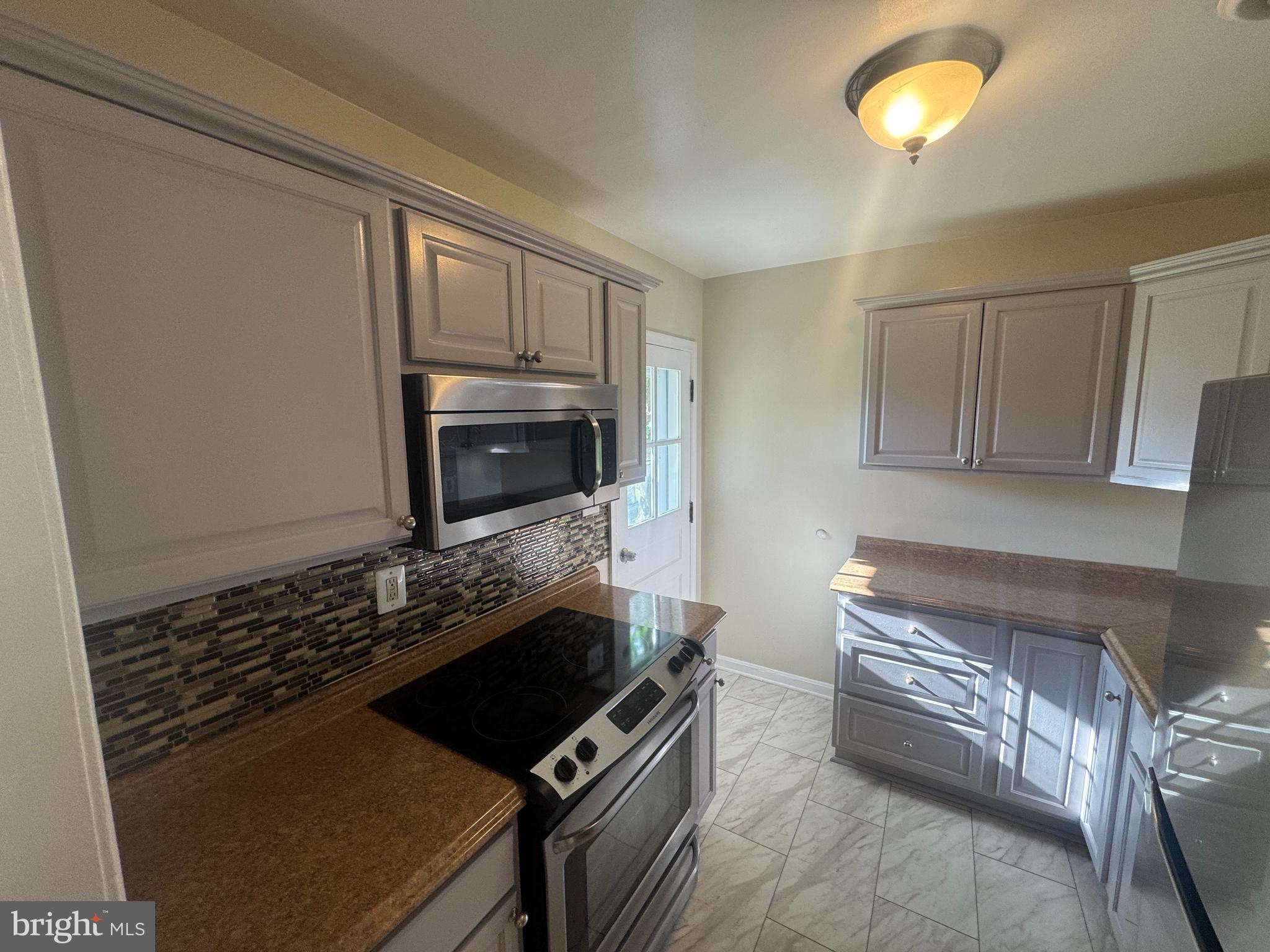 2810 Xavier Lane District Heights, MD 20747 - Photo 3 of 27 a kitchen with a stove and a microwave