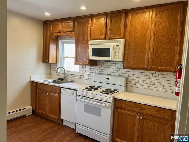 a kitchen with a sink stove top oven and cabinets