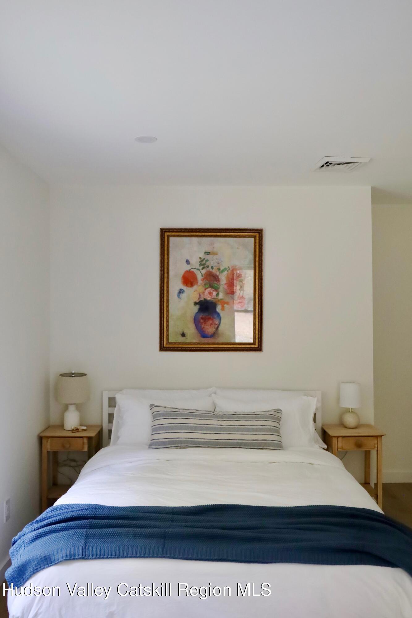 230 Potic Mountain Road Athens, NY 12414 - Photo 15 of 25 a bedroom with a bed and a wall painting