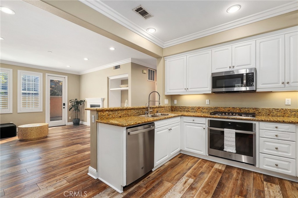 12 Globe Lane Ladera Ranch, CA 92694 - Photo 12 of 37 a kitchen with stainless steel appliances granite countertop a stove and a sink