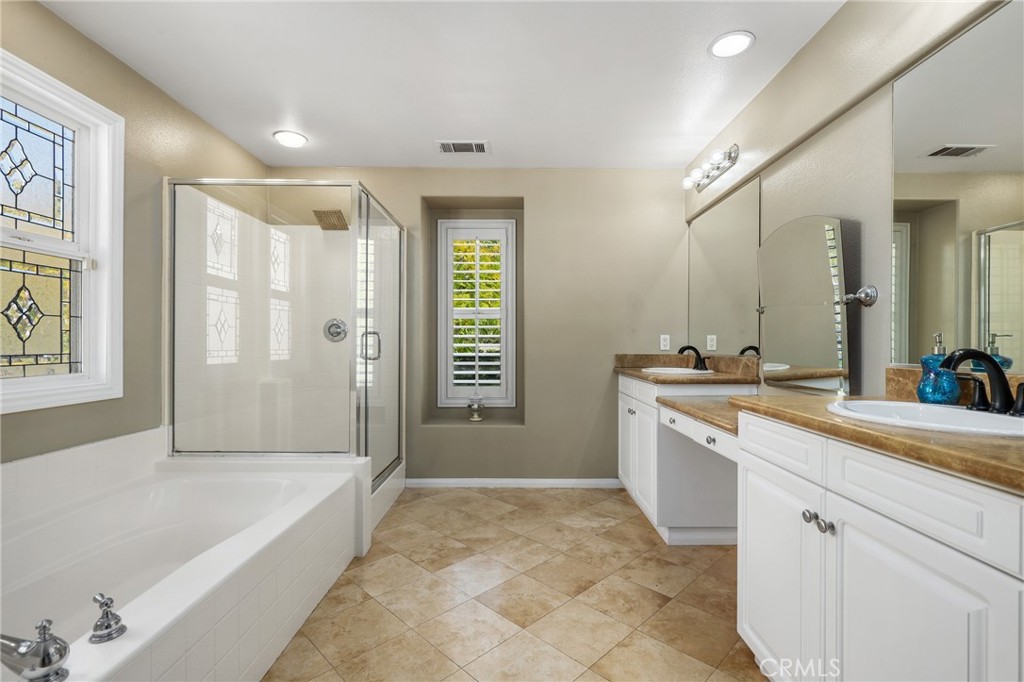 12 Globe Lane Ladera Ranch, CA 92694 - Photo 21 of 37 a spacious bathroom with a bathtub sink and mirror