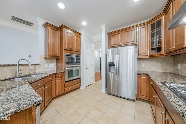 a kitchen with stainless steel appliances granite countertop a refrigerator stove and oven