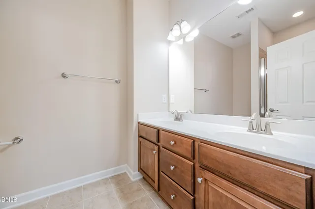 a bathroom with a double vanity sink and a mirror