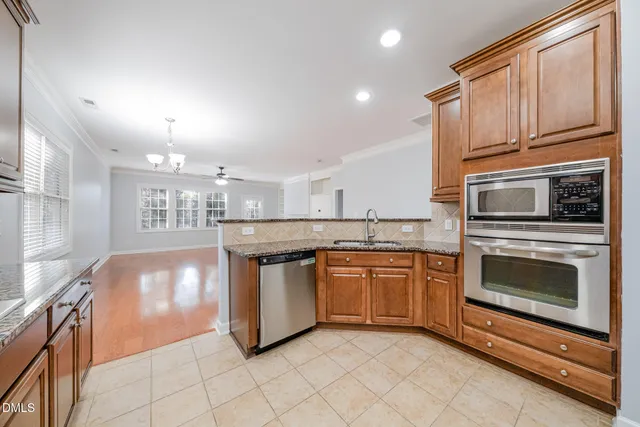 a kitchen with stainless steel appliances granite countertop a stove a sink and a microwave