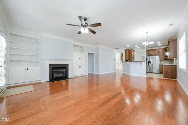 a view of empty room with wooden floor and fireplace