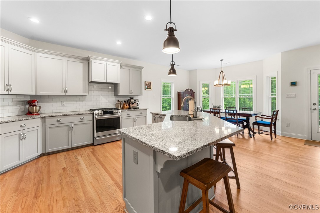 216 Edwin Circle Aylett, VA 23009 - Photo 12 of 27 a open kitchen with stainless steel appliances granite countertop a stove top oven a refrigerator a sink dishwasher a dining table and chairs with wooden floor