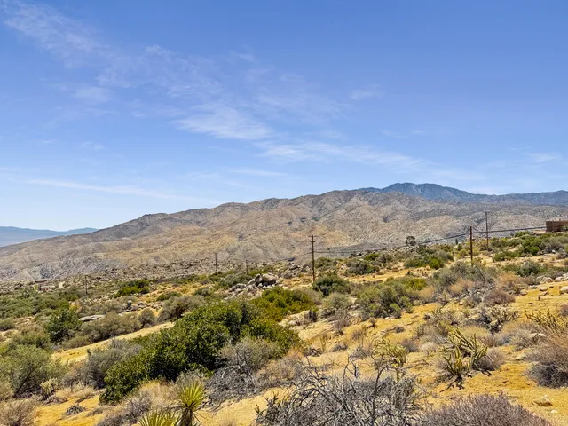 a view of a dry yard with mountains in the background
