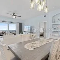 a kitchen with stainless steel appliances granite countertop a stove a sink a refrigerator with a dining table and chairs