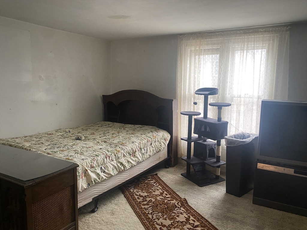 25 West Baltimore Street Lynn, MA 01902 - Photo 13 of 15 a bedroom with a bed and wooden floor