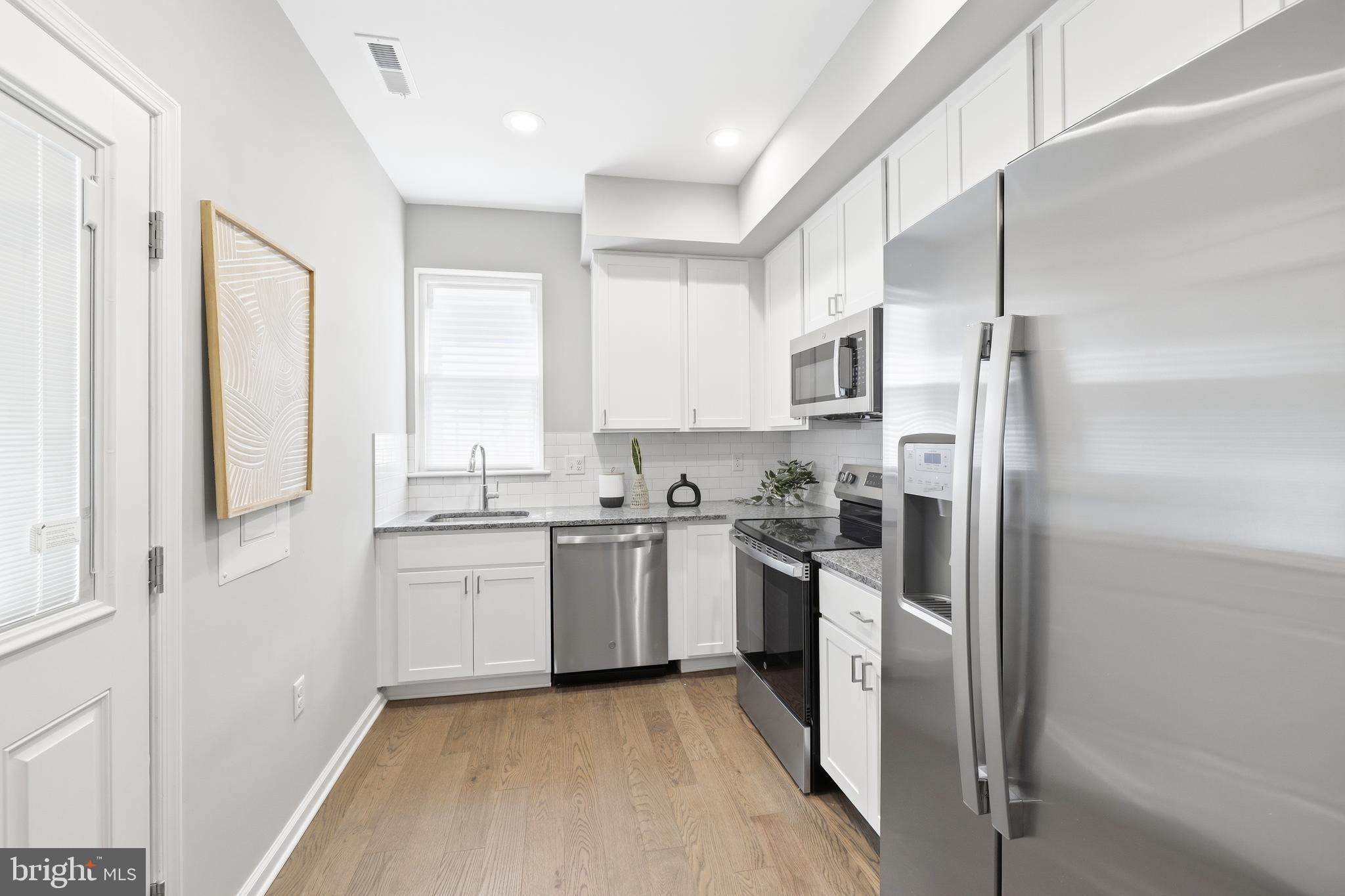 703 East Preston Street Baltimore, MD 21202 - Photo 5 of 26 a kitchen with a refrigerator stove top oven and sink