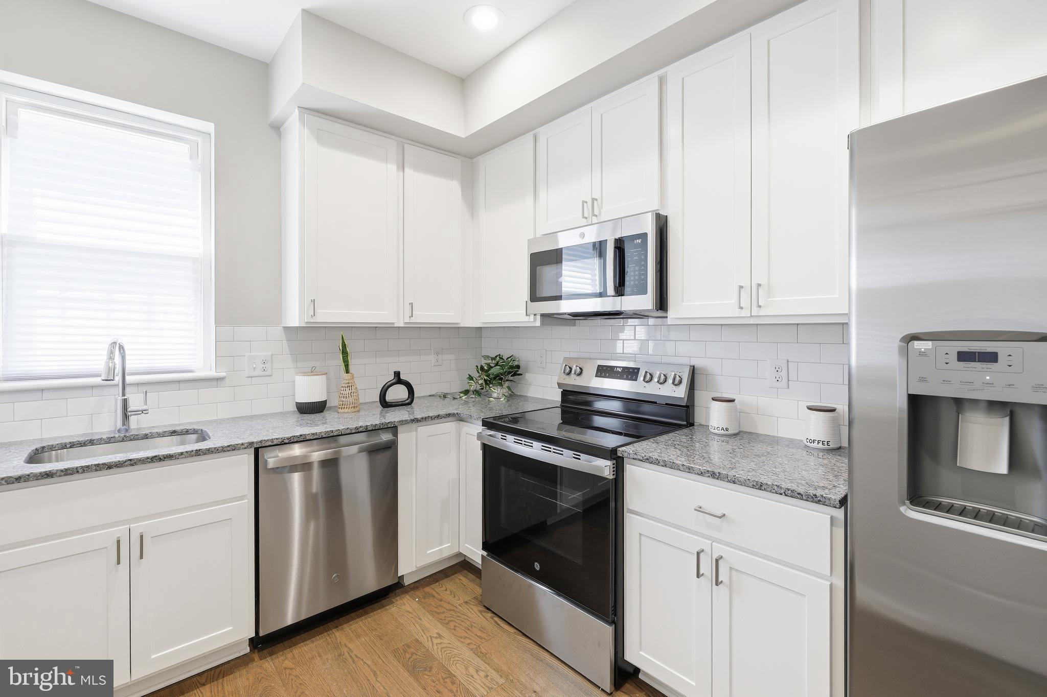 703 East Preston Street Baltimore, MD 21202 - Photo 6 of 26 a kitchen with cabinets appliances a sink and a window