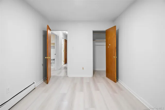 a view of an empty room with closet and a window