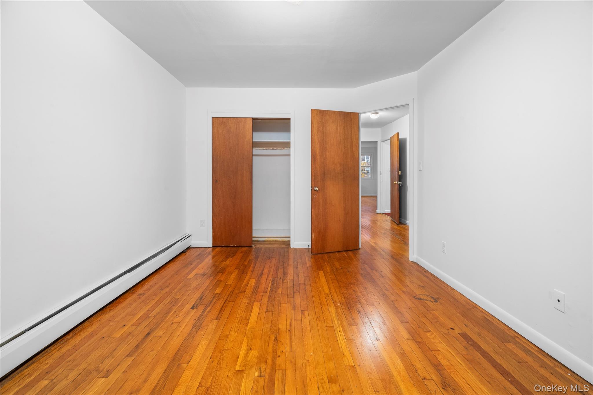 178-59 Wexford Terrace Queens, NY 11432 - Photo 23 of 45 a view of an empty room with wooden floor and a window