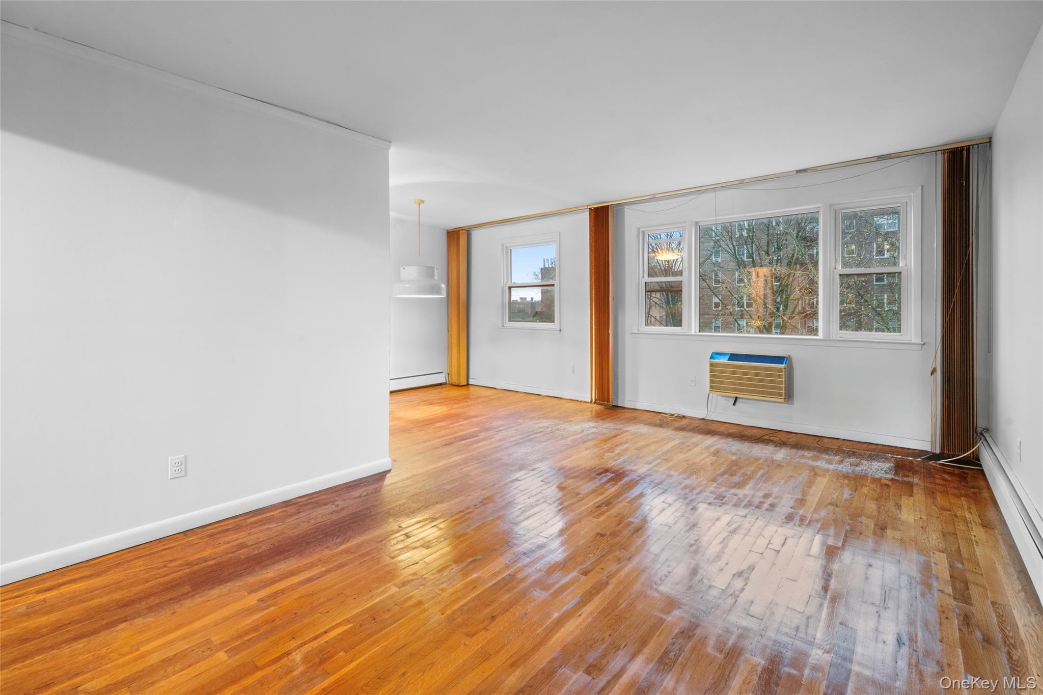 178-59 Wexford Terrace Queens, NY 11432 - Photo 25 of 45 a view of an empty room with wooden floor and a window