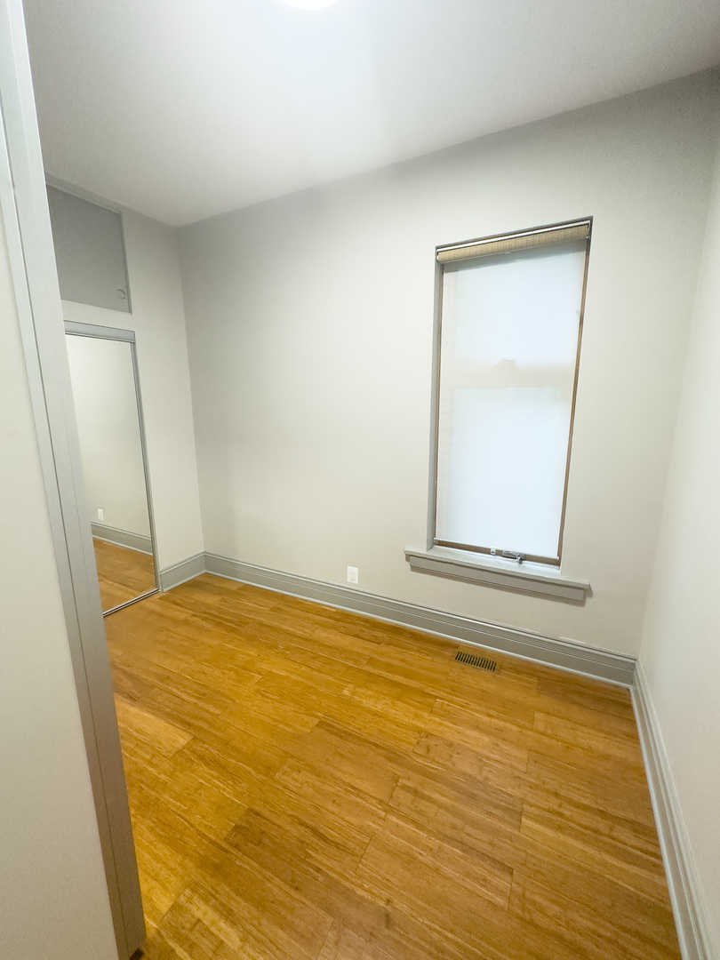 3714 South Indiana Avenue, Unit 2 Chicago, IL 60653 - Photo 16 of 18 a view of empty room with window and hardwood floor