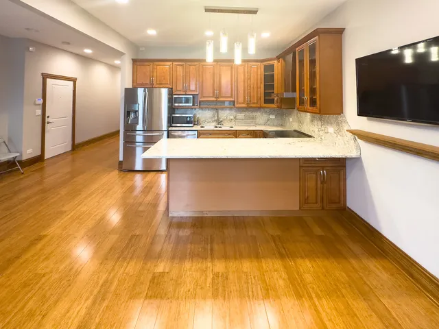 a view of kitchen with kitchen island a sink and a large refrigerator