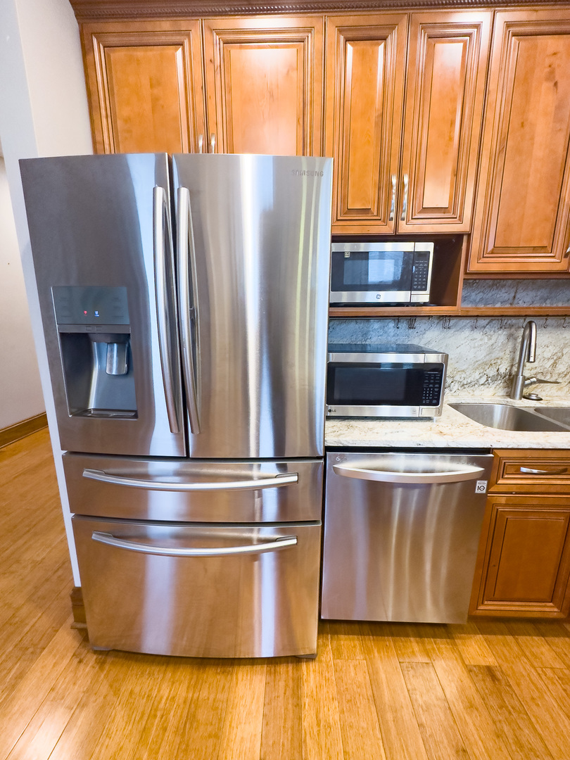 3714 South Indiana Avenue, Unit 2 Chicago, IL 60653 - Photo 8 of 18 a view of a kitchen with wooden floors and stainless steel appliances