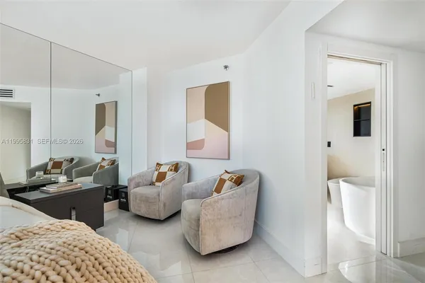 a bedroom with furniture and a large mirror