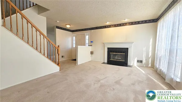 a view of an empty room with a fireplace and a window