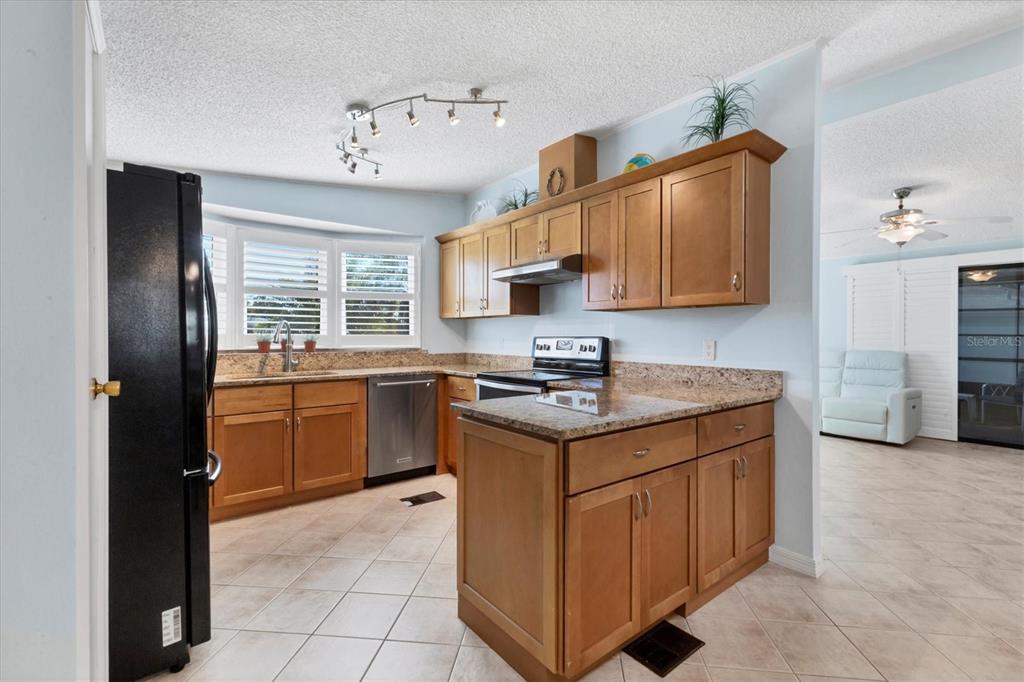159 Osprey Circle Ellenton, FL 34222 - Photo 5 of 37 a kitchen with a stove a sink a refrigerator and cabinets