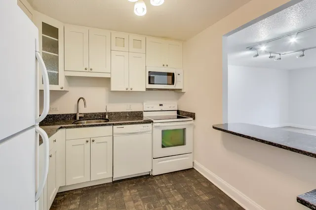 a kitchen with stainless steel appliances granite countertop a sink and a stove