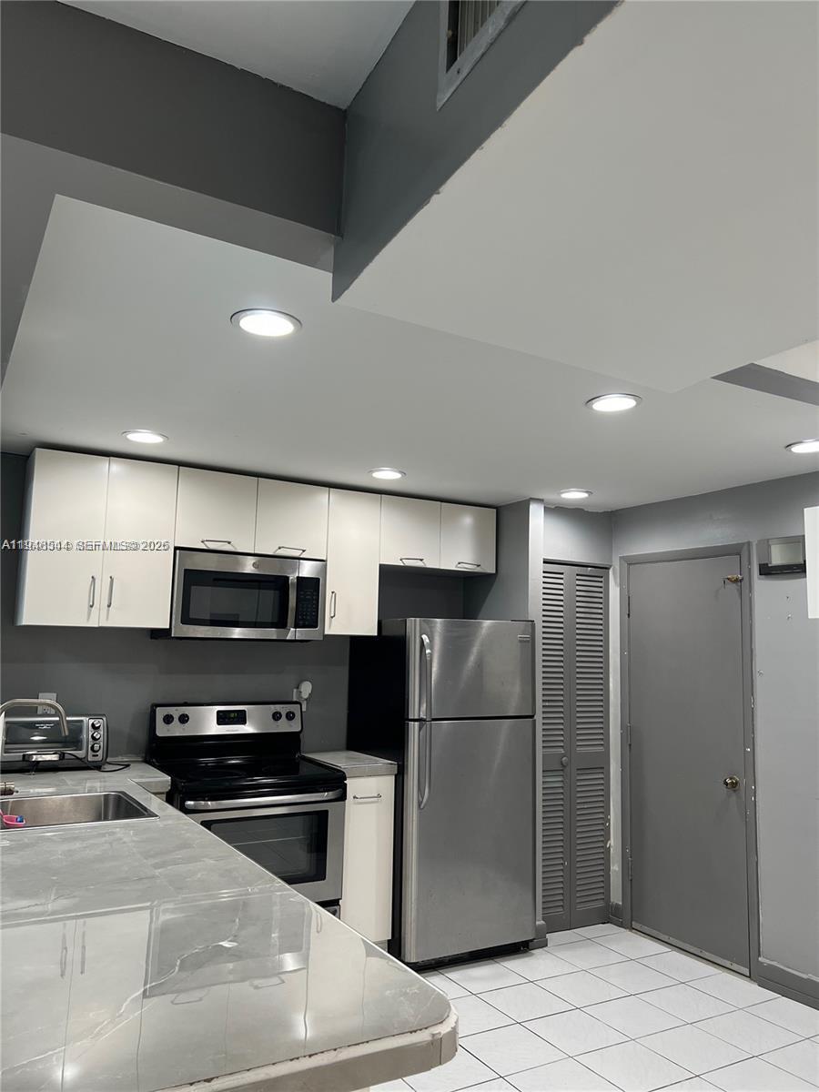 a kitchen with stainless steel appliances a refrigerator and a stove top oven