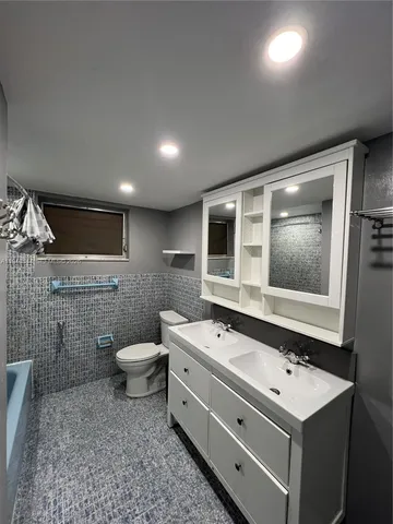a spacious bathroom with a toilet a sink and mirror