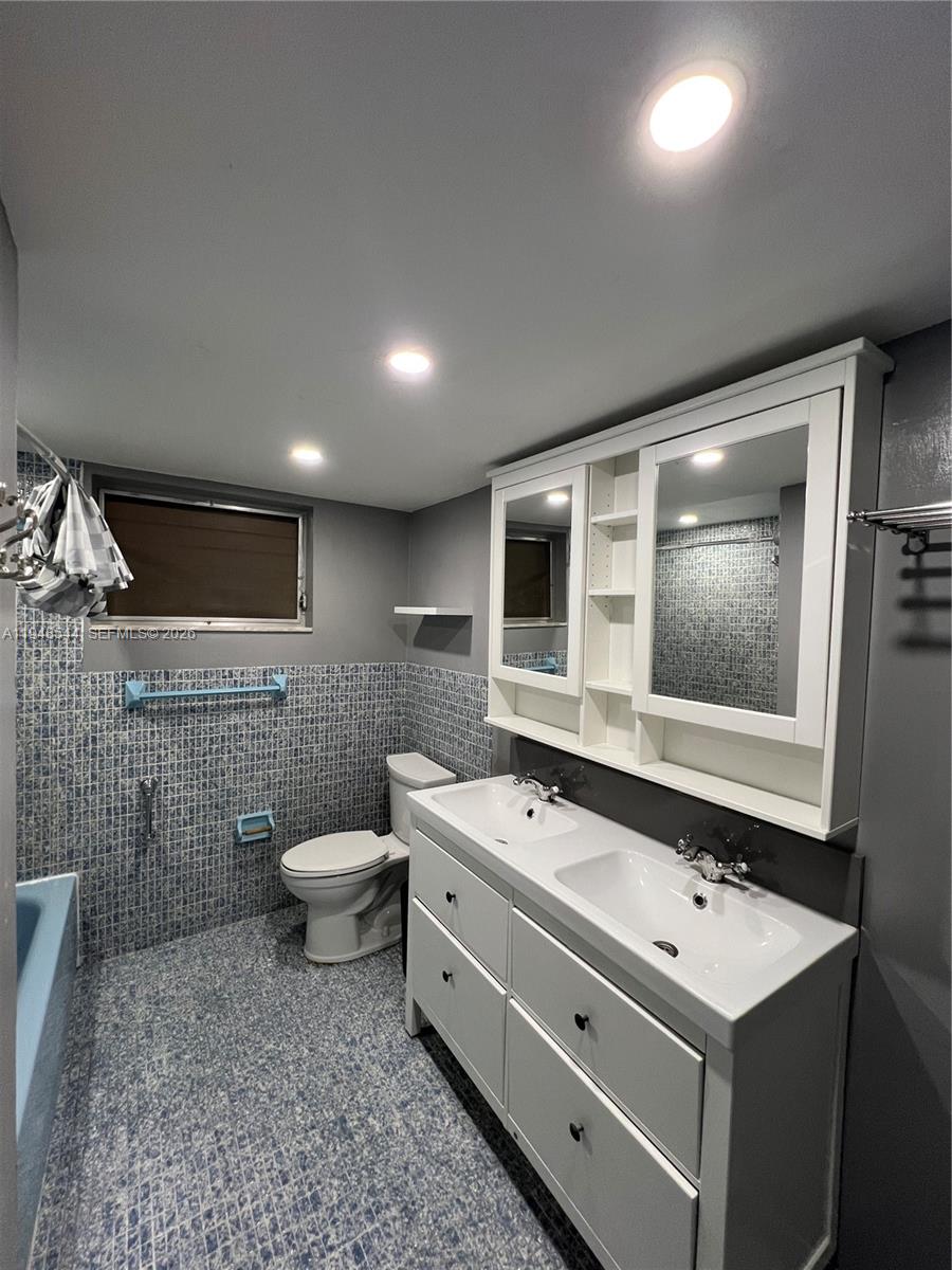 1710 Northeast 191st Street, Unit 1003 Miami, FL 33179 - Photo 12 of 16 a spacious bathroom with a toilet a sink and mirror