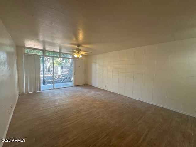 1101 East Bethany Home Road, Unit 16 Phoenix, AZ 85014 - Photo 3 of 15 en empty room with windows and ceiling fan